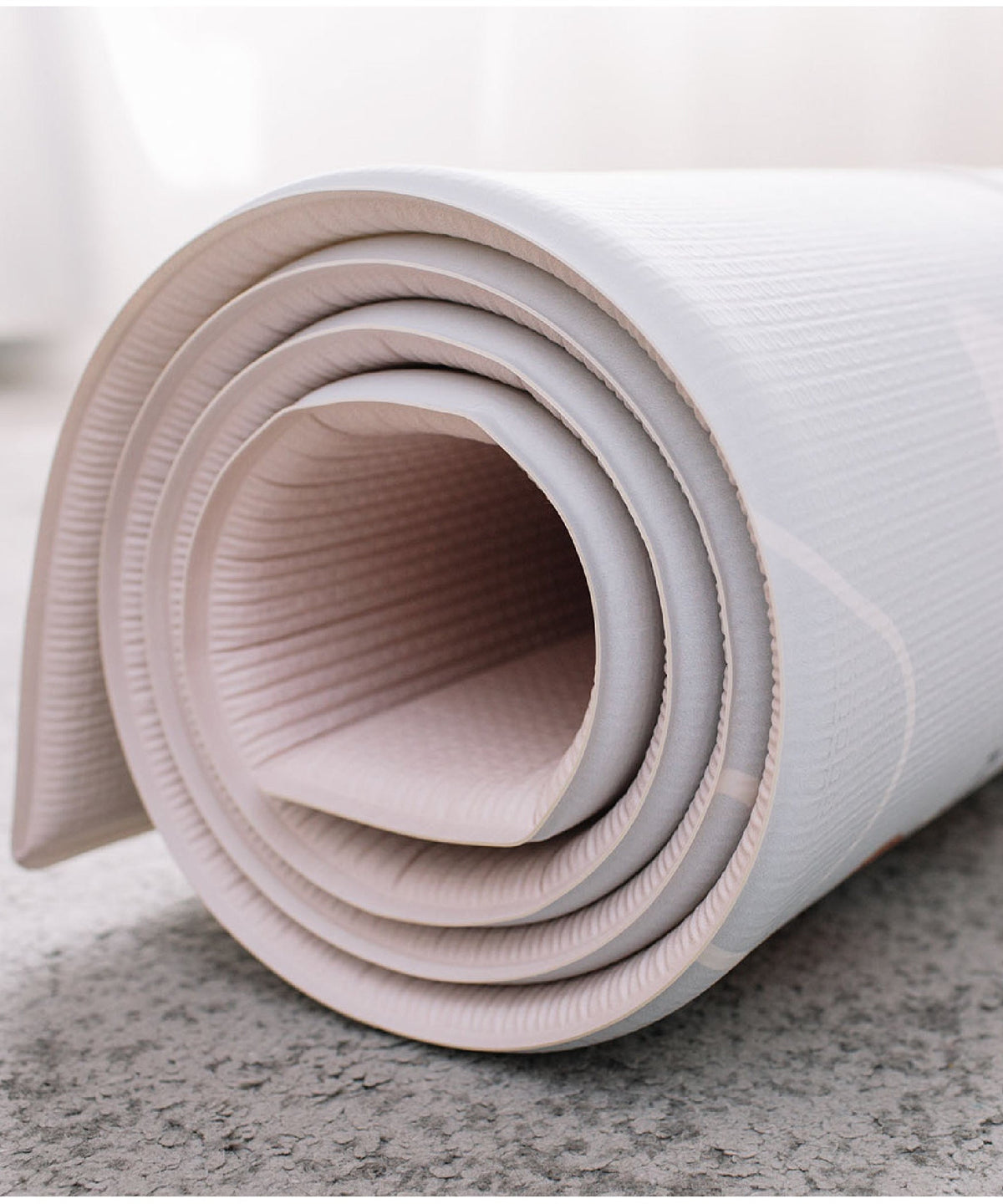 Rolled-up reversible playmat with colorful Hong Kong City designs on a light surface