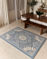 Floral patterned rug on a tiled floor in a room with a table and chairs.