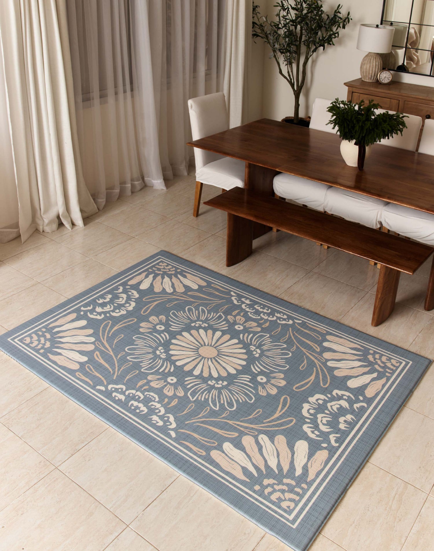 Floral patterned rug on a tiled floor in a room with a table and chairs.